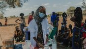 Photo of service provider in rural area, with mask and medical supplies